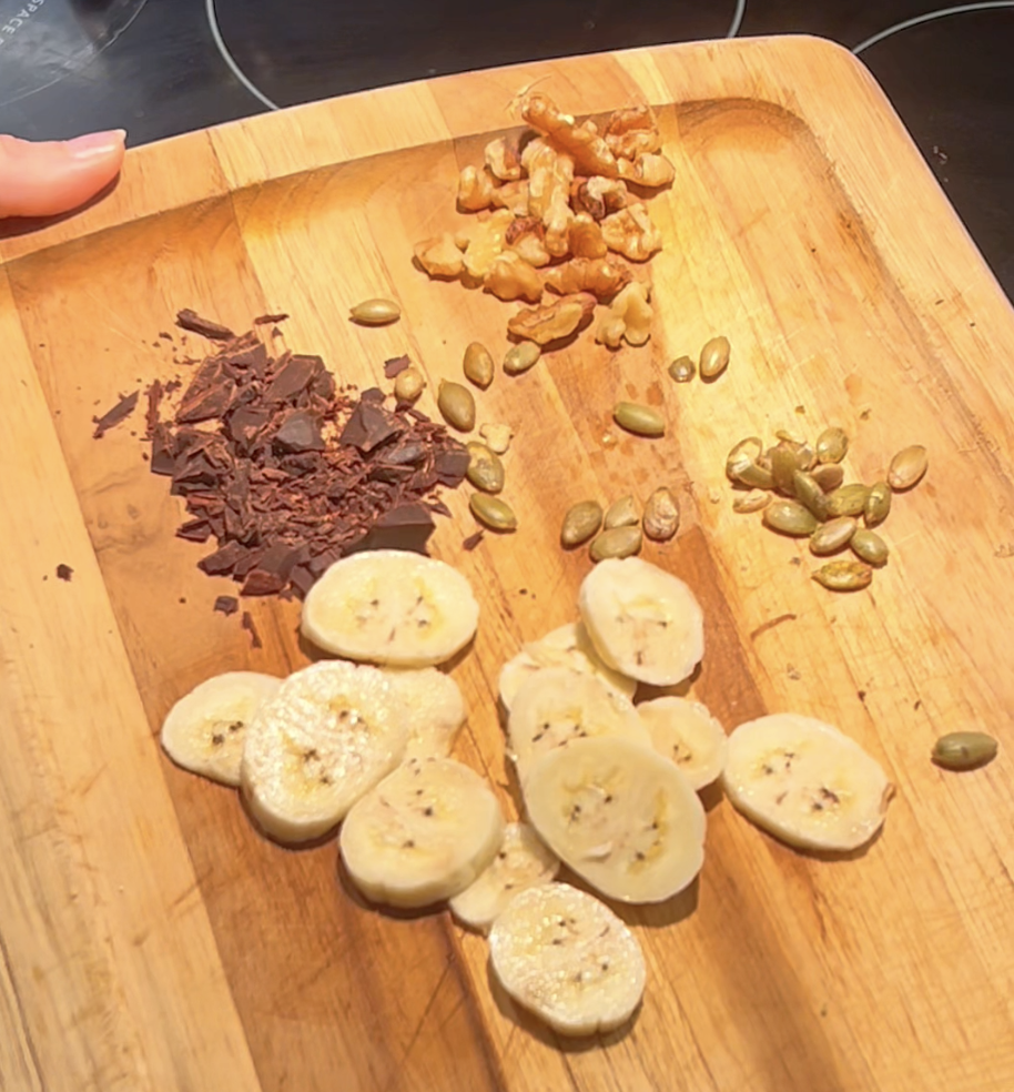 Close-up of a sourdough discard crepe with banana slices, pumpkin seeds, walnuts, and dark chocolate for a sweet breakfast option.